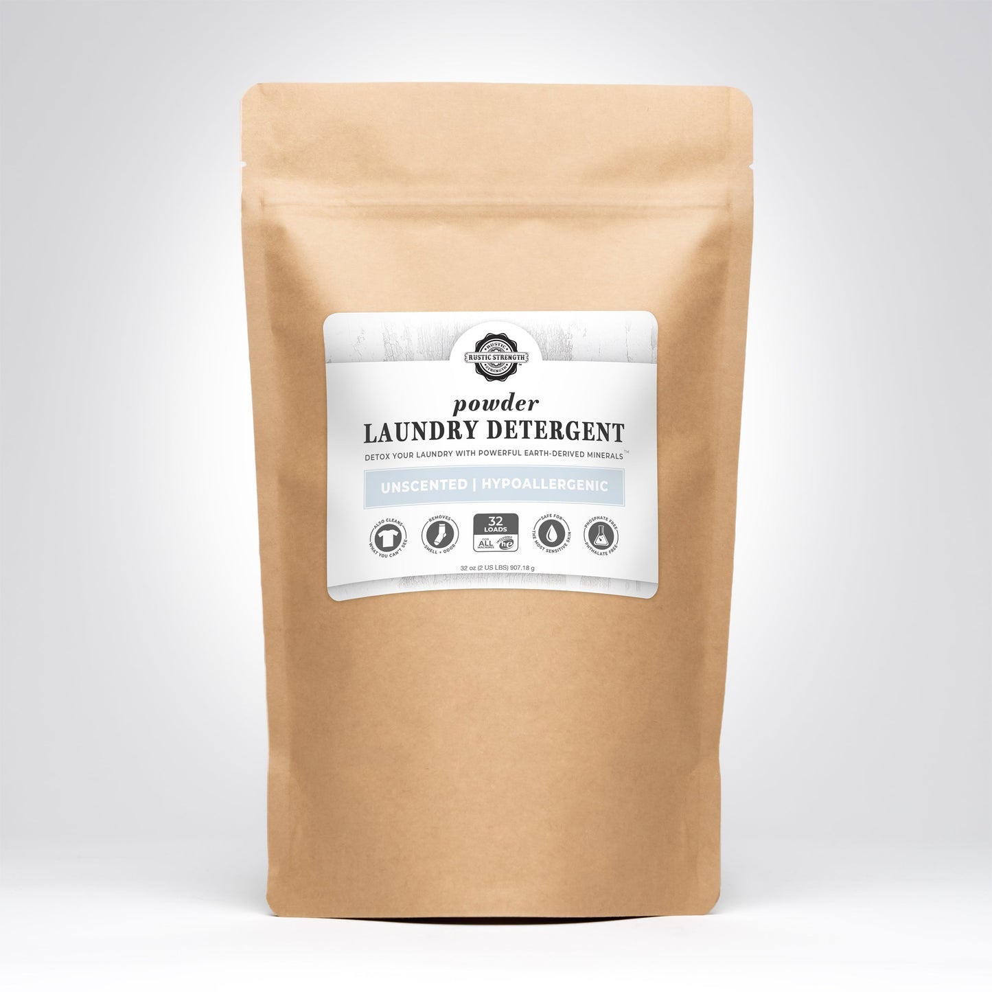A brown paper bag of Rustic Strength Powder Laundry Detergent with a white label displays features like unscented, hypoallergenic, and 32 loads, set against a plain gray background.
