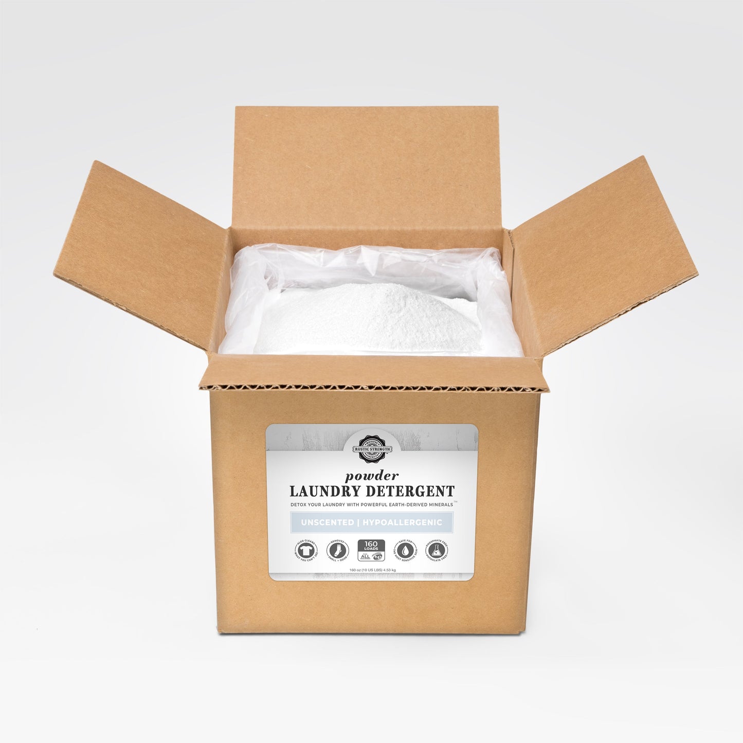 An open brown cardboard box reveals a bag of Rustic Strength Powder Laundry Detergent. The label reads: Laundry Detergent, Unscented, Hypoallergenic, with several icons and product details.