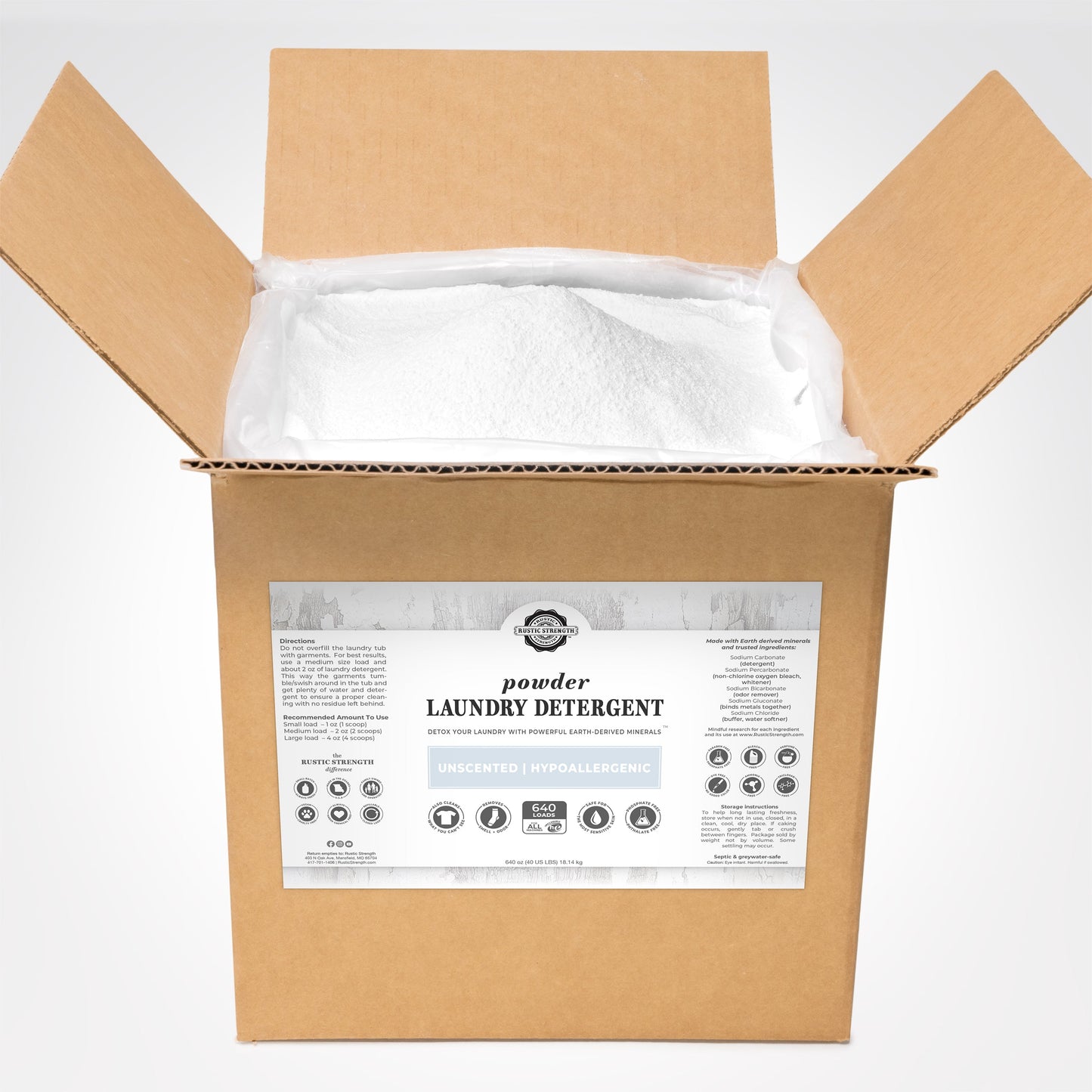 An open cardboard box filled with white powder laundry detergent. A white label on the front displays Powder Laundry Detergent and the brand name Rustic Strength. The detergent is unscented and hypoallergenic.