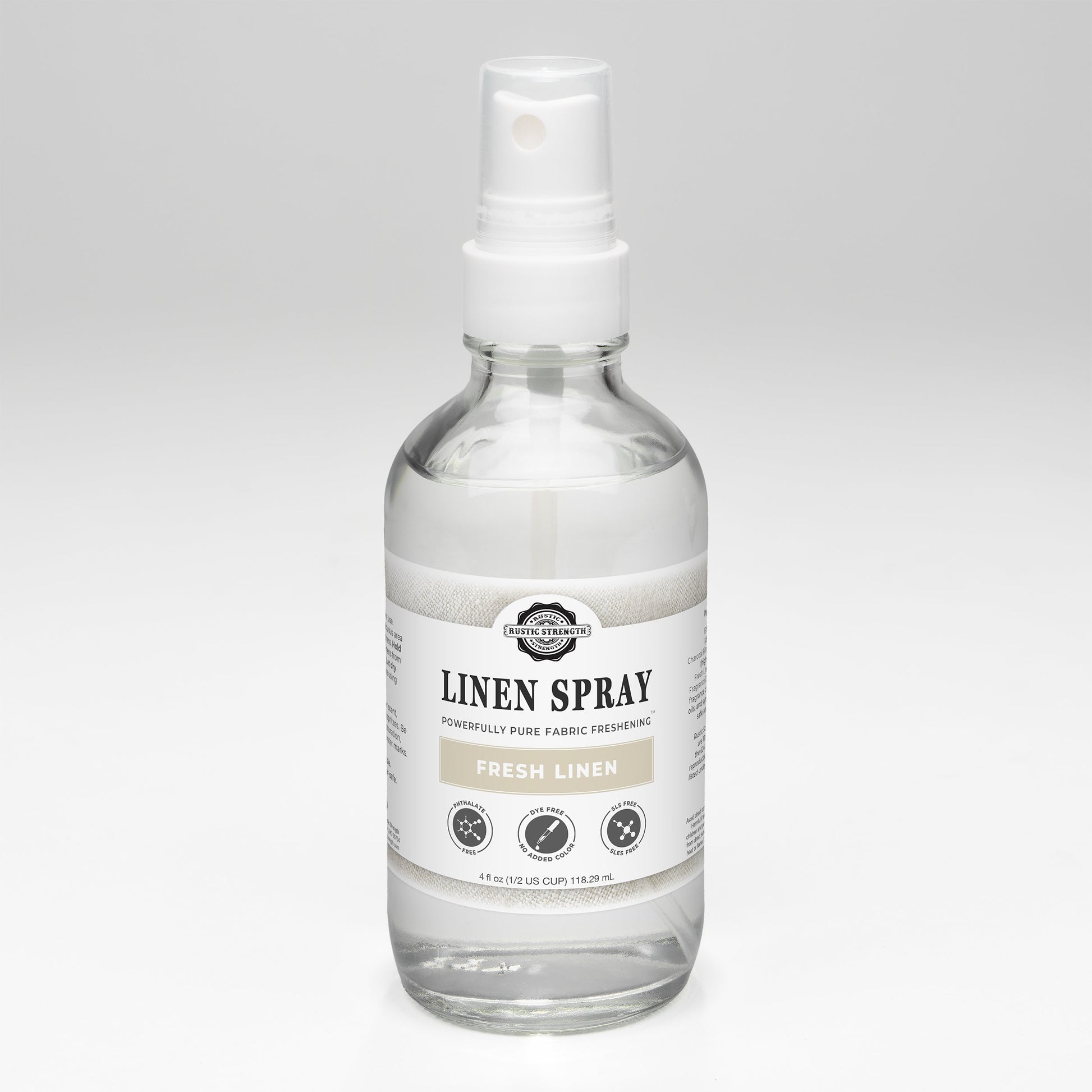 Rustic Strength Fresh Linen Spray featuring a clear glass bottle with a white spray nozzle and a minimalist label.