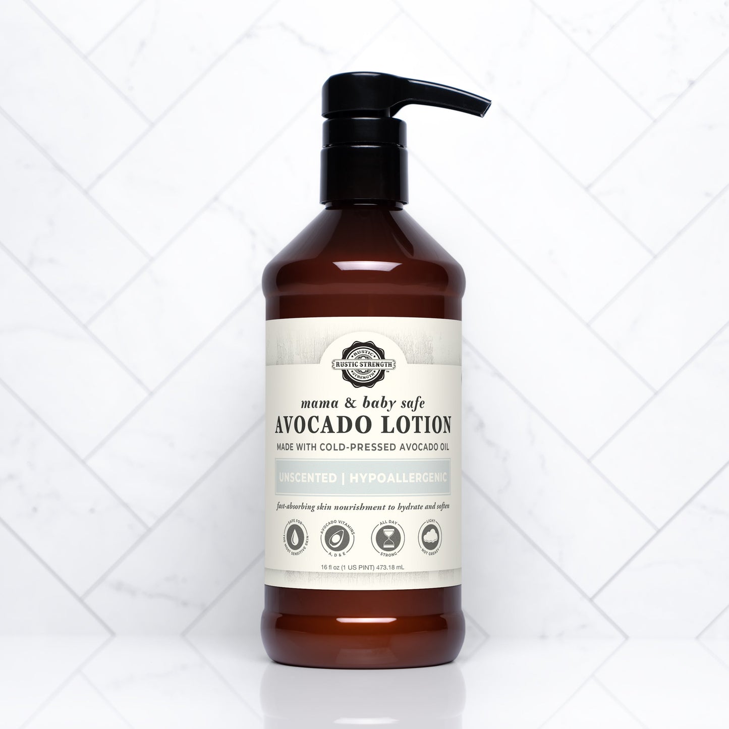 A brown pump bottle of Rustic Strength Avocado Lotion | Mama + Baby Safe, featuring plant-based, unscented, hypoallergenic care with cold-pressed avocado oil for gentle nourishment, set against a white tiled background.