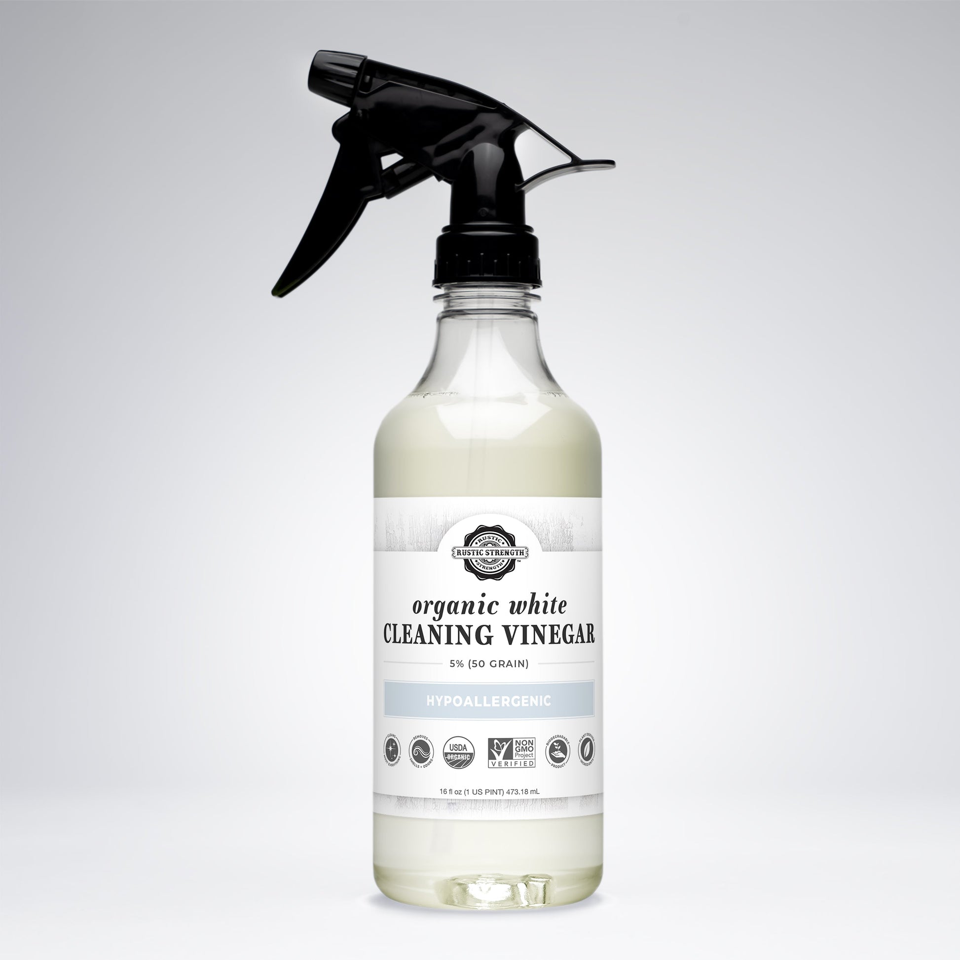 A clear glass spray bottle of Rustic Strength Organic White Cleaning Vinegar | 5% (50 grain), labeled Non-GMO, biodegradable, and hypoallergenic with a black nozzle, stands upright on a plain white background.