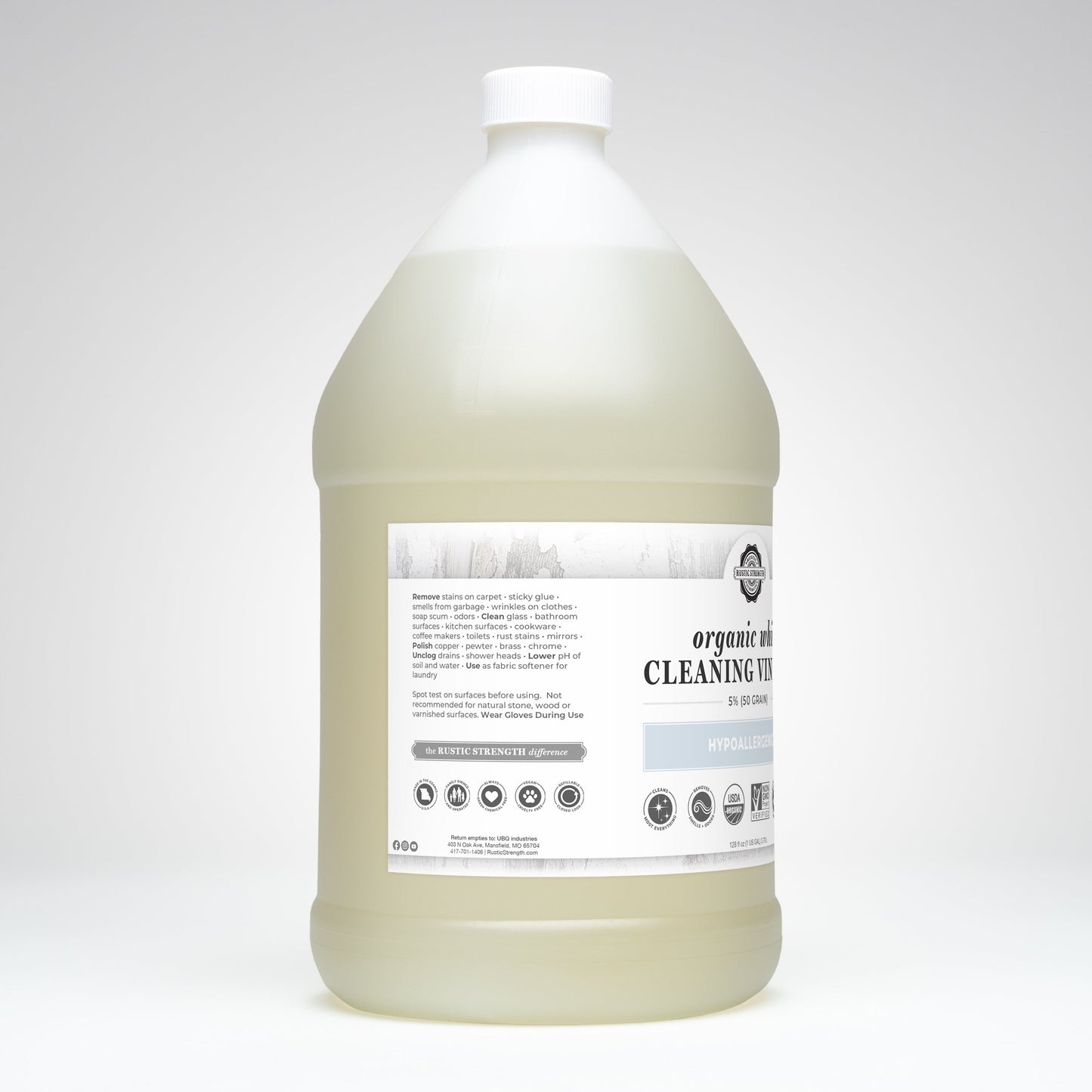 A large, clear gallon jug of Rustic Strength Organic White Cleaning Vinegar | 5% (50 grain), with a white cap and pale yellow, Non-GMO, biodegradable liquid. The label has black/gray text detailing usage on a plain white background.