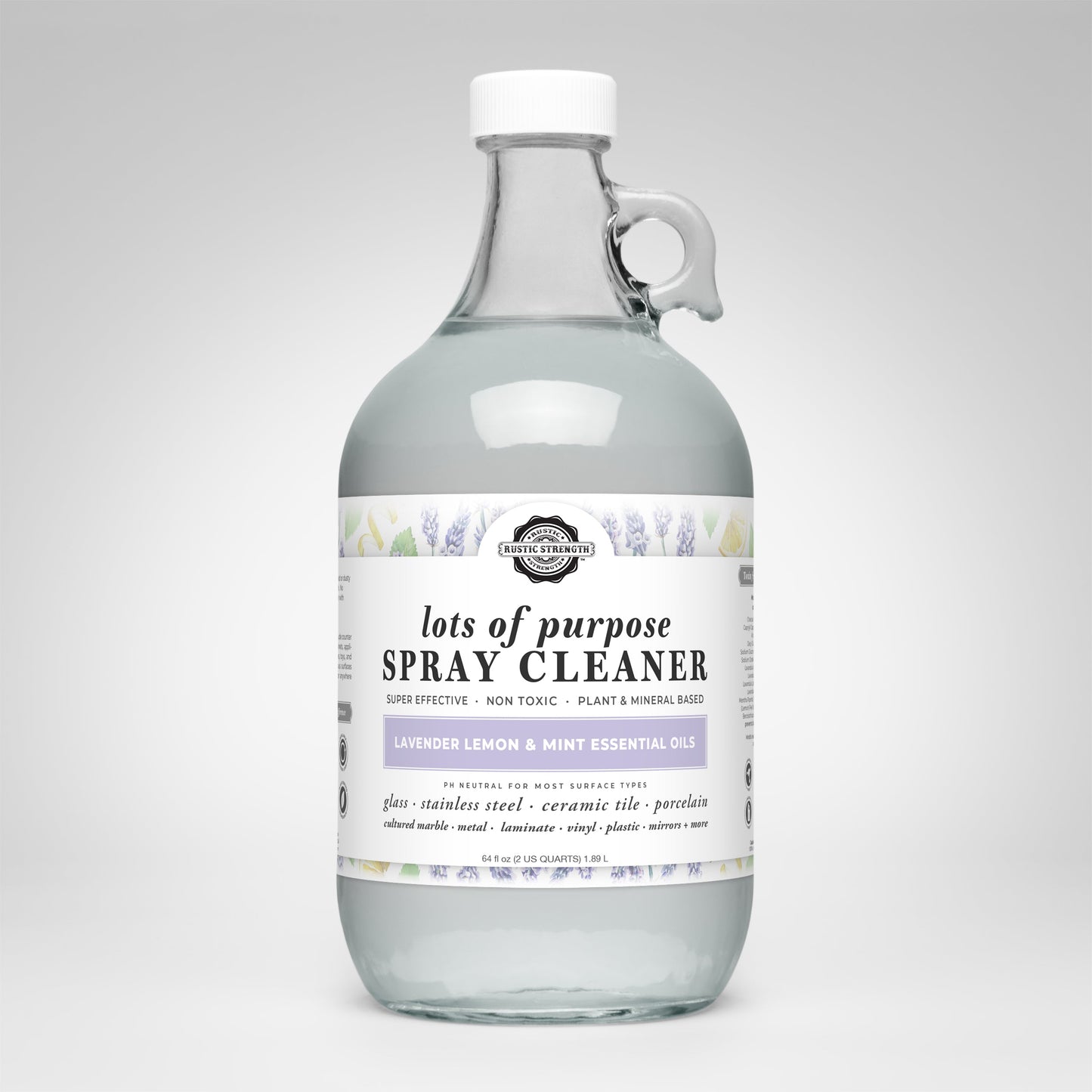 A clear glass bottle with a white cap contains Rustic Strengths Lots of Purpose Spray Cleaner | Lavender, Lemon & Mint, a toxin-free, plant and mineral-based cleaner for non-porous surfaces with essential oils.