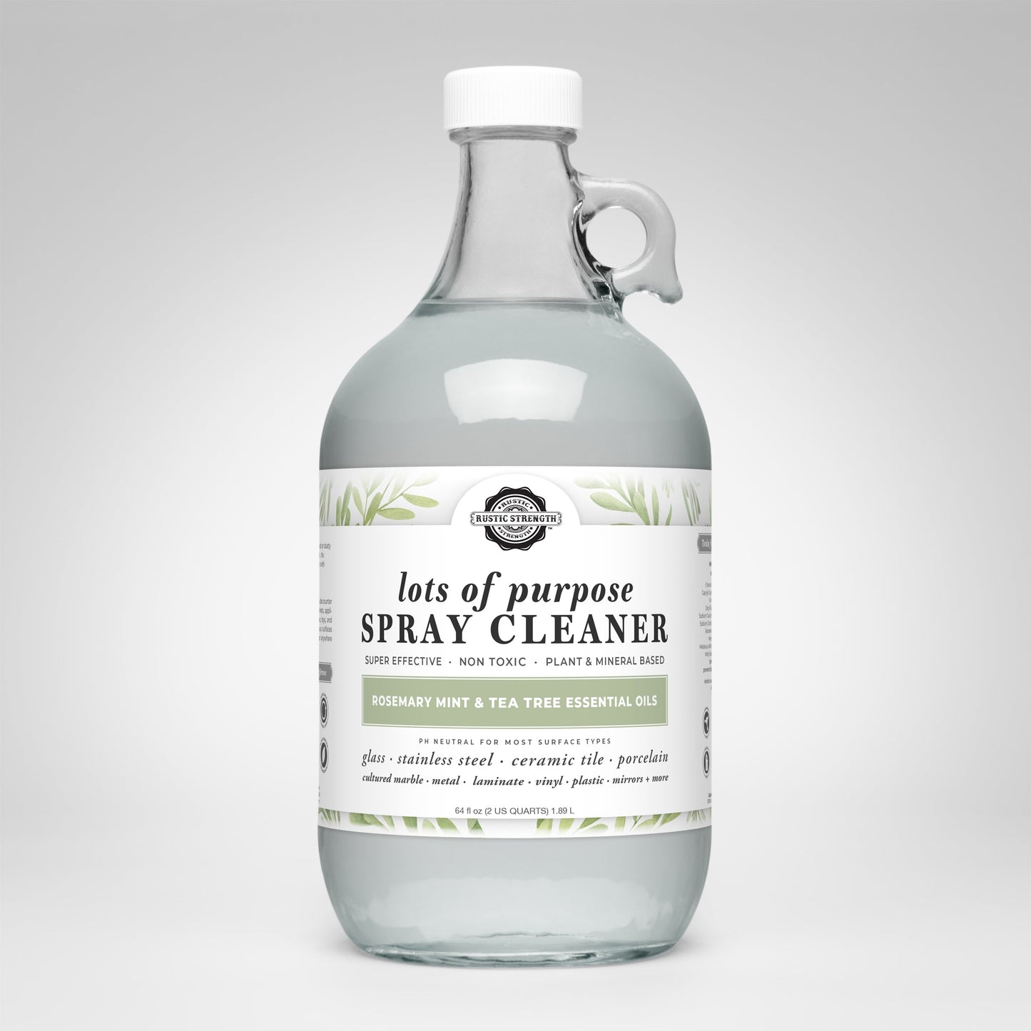 A clear glass bottle with a white cap labeled Lots of Purpose Spray Cleaner | Rosemary, Mint & Tea Tree by Rustic Strength. The label has green leaf accents and highlights its plant-based, toxin-free cleaner formula.