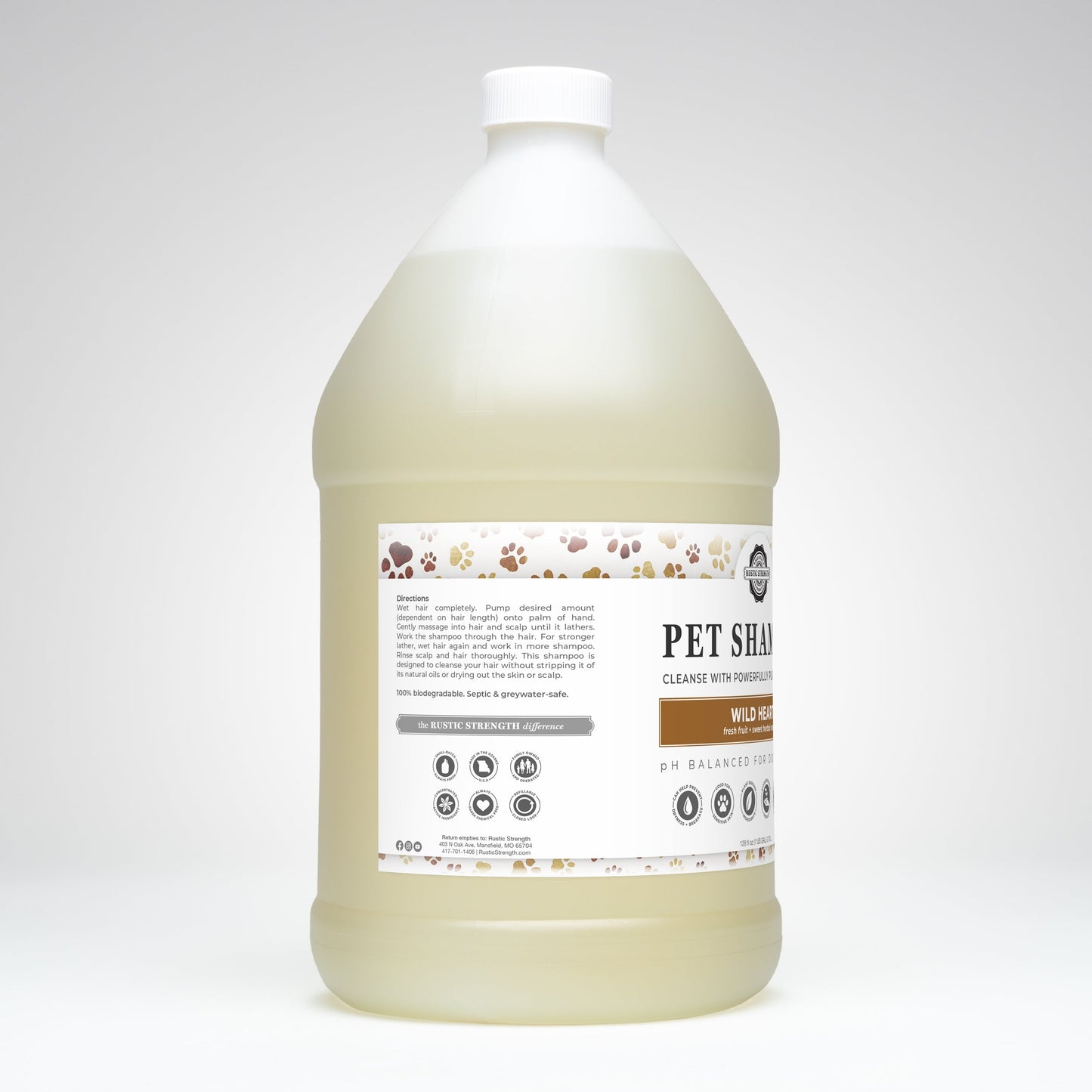 A large, clear plastic gallon jug with a white cap contains light yellow Pet Shampoo by Rustic Strength—Soothing & Deodorizing, plant-based and non-toxic. The label features paw prints and product info, branded as Wild Heart.