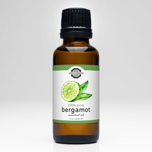 Rustic Strength Bergamot Essential Oil comes in a brown glass bottle with a black cap. The label shows a green bergamot fruit, notes 1 fl oz (29.55 ml), and reads 100% pure. Ideal for aromatherapy or as a refreshing laundry scent.