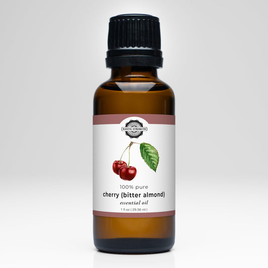 Rustic Strength Cherry (Bitter Almond) Essential Oil comes in a 1 fl oz (29.56 ml) brown glass bottle with black cap, labeled 100% pure. Ideal for aromatherapy or laundry use; label shows two cherries and a green leaf.