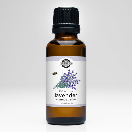 A 1 fl oz (29.55 mL) brown glass bottle of Rustic Strength Lavender Essential Oil features a black cap, a white label with lavender flowers and bee art, and is ideal for aromatherapy with its 100% pure premium blend.