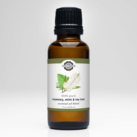 A brown glass bottle with a black cap, labeled Rustic Strength Rosemary, Mint & Tea Tree Essential Oil Blend for aromatherapy, features illustrations of rosemary, mint, and tea tree leaves on a white background.