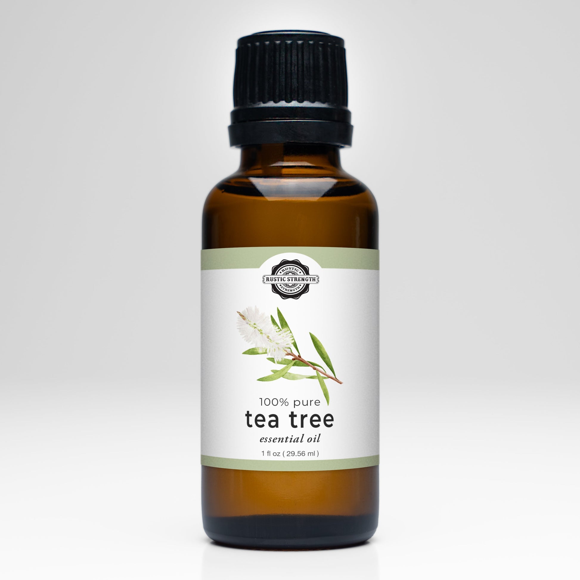A brown glass bottle with a black cap, labeled Tea Tree Essential Oil by Rustic Strength, features tea tree leaves and a white flower—ideal for aromatherapy and other essential oil uses.
