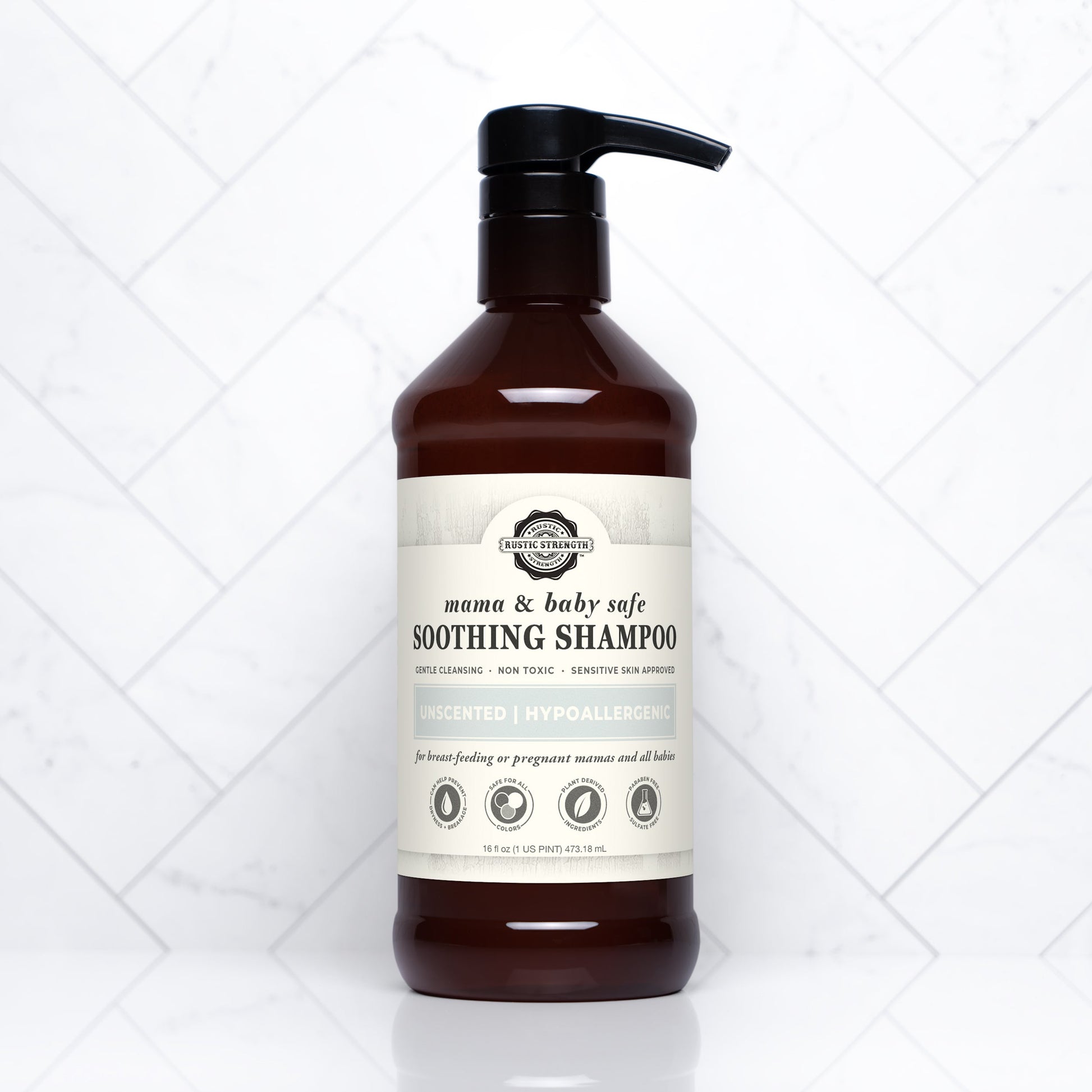 A brown plastic pump bottle of Rustic Strength Soothing Shampoo | Mama + Baby Safe, featuring an unscented, plant-based formula that’s hypoallergenic, pH balanced, and safe for pregnant moms and babies, stands on white tiles.
