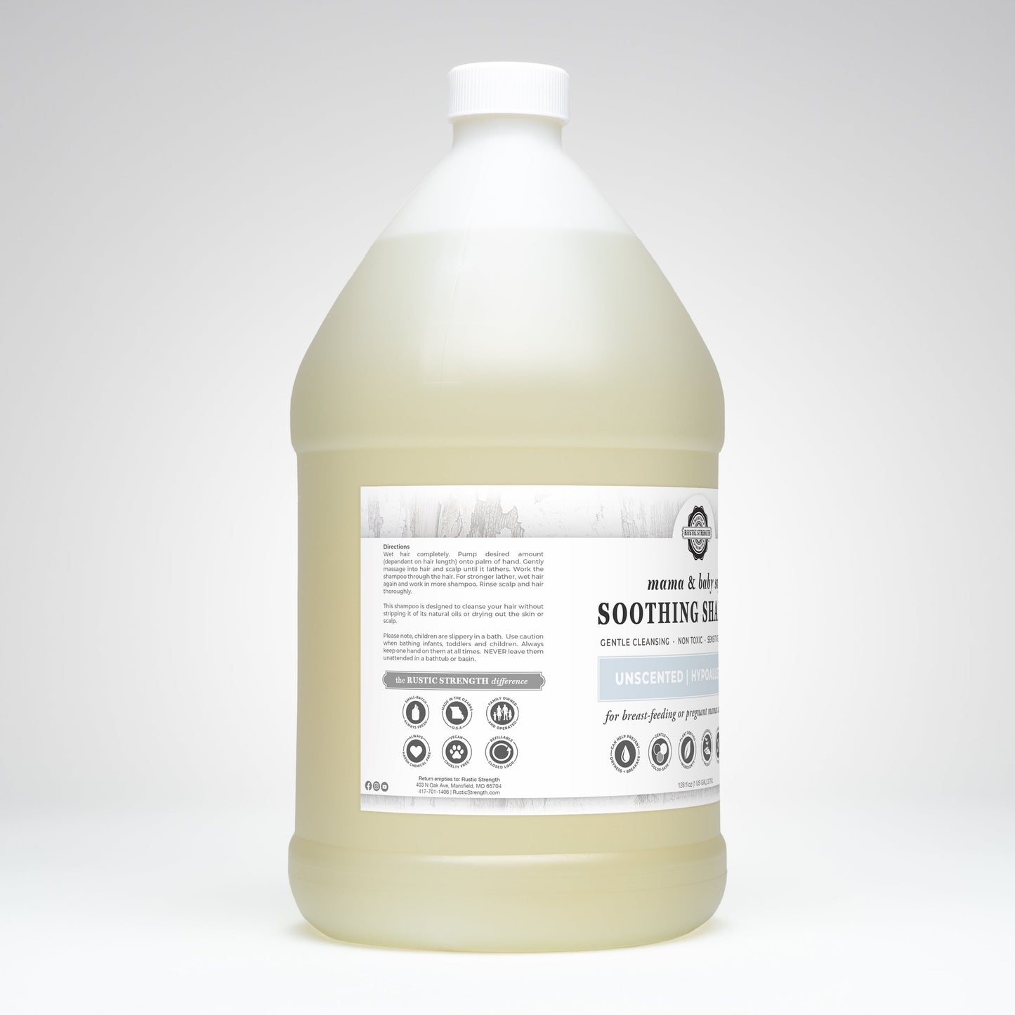 A large, translucent gallon jug with a white cap holds light yellow Soothing Shampoo | Mama + Baby Safe by Rustic Strength. The white and gray label features plant-based formula details, usage instructions, and safety icons.