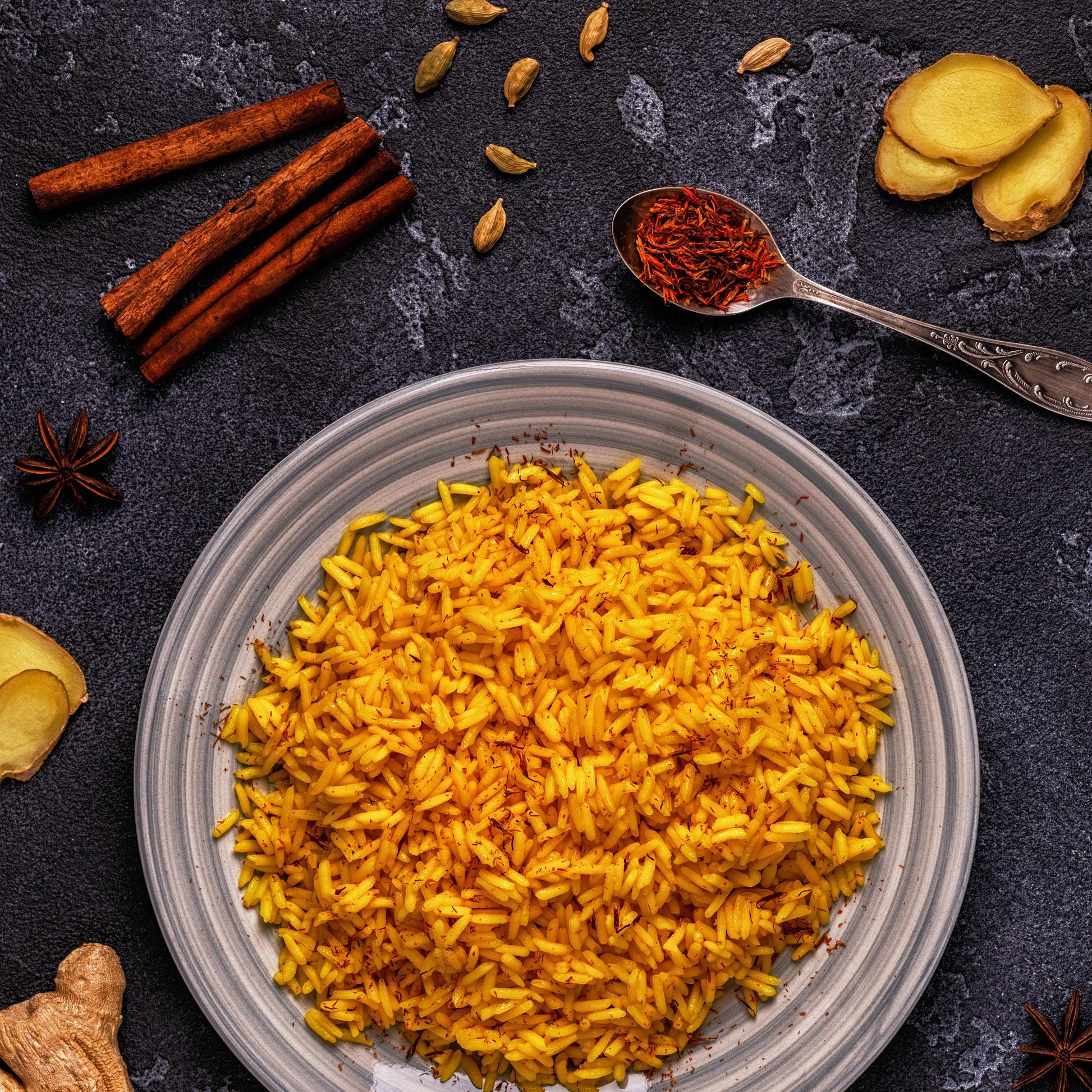 Premium Saffron Threads from Vanilla Bean Kings displayed with Persian and Basmati rice, showcasing vibrant saffron in a culinary setting.