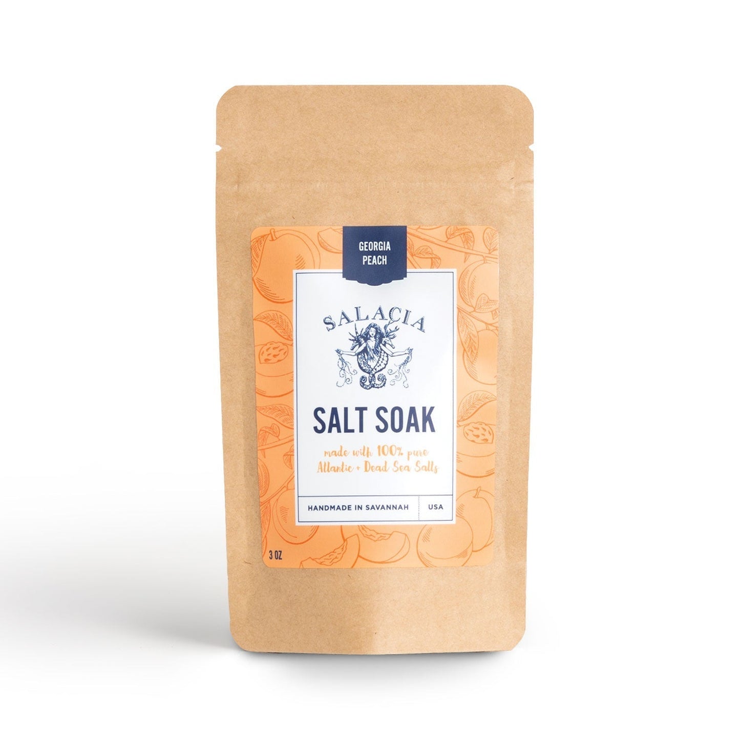 A brown resealable pouch labeled Salacia Salts Georgia Peach Small Salt Soak features an orange design. This skin-softening soak is handmade in Savannah, USA, with Atlantic sea salts for a perfect detox bath experience.