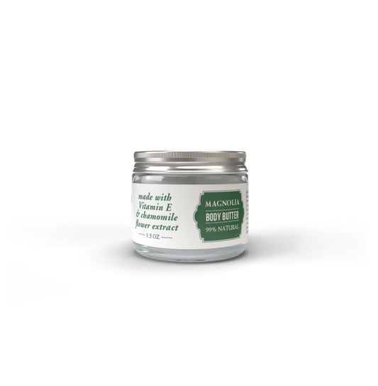A clear glass jar with a silver lid, labeled Salacia Salts Magnolia Body Butter. This 1.5 oz, 99% natural product is enriched with Vitamin E, chamomile flower extract, and beeswax for luxurious skin care.