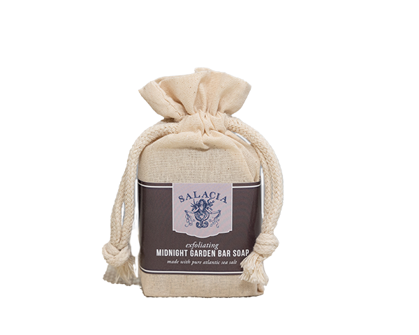 A beige fabric drawstring bag with thick rope ties holds the Salacia Salts Midnight Garden Bar Soap, a natural soap crafted with pure Atlantic sea salt. The simple, elegant packaging highlights this luxurious Atlantic sea salt bar.