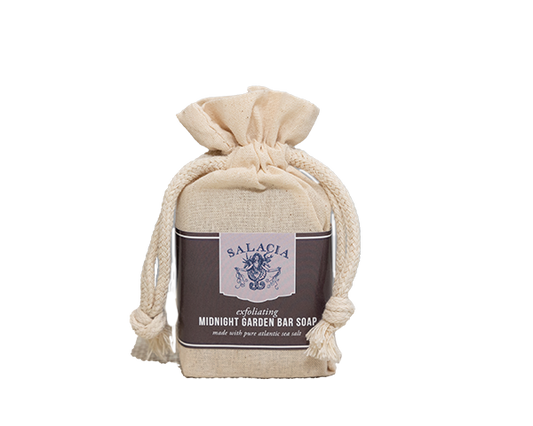 A beige fabric drawstring bag with thick rope ties holds the Salacia Salts Midnight Garden Bar Soap, a natural soap crafted with pure Atlantic sea salt. The simple, elegant packaging highlights this luxurious Atlantic sea salt bar.