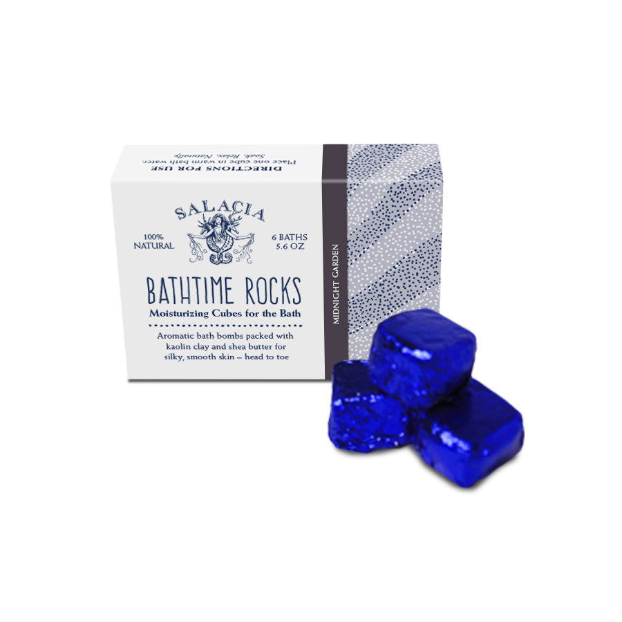 A box labeled Salacia Salts Midnight Garden BathTime Rocks (Set of 6) with three shiny blue bath cubes beside it. The packaging highlights moisturizing fizzy soak cubes with essential oils and a Midnight Garden scent.