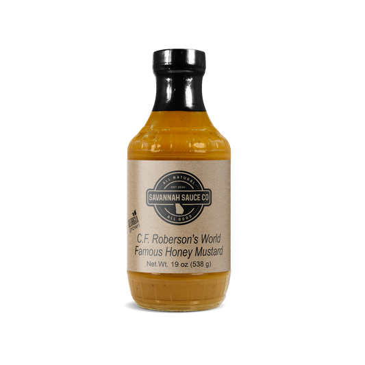 SavannahSauceCompany's C.F. Roberson’s World Famous Honey Mustard 12 CT CASE, each bottle with a beige label and black cap, is shown against a plain white background. Also available in an 18 oz bottle for your convenience.