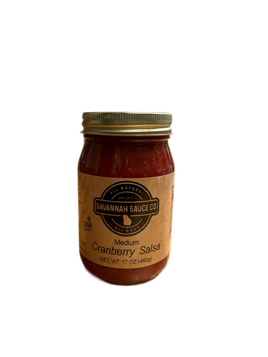 A glass jar of SavannahSauceCompany’s New Seasonal Cranberry Salsa case, featuring a gold lid and brown label, holds 17 oz (482g) of salsa. Ideal for holidays, the jar is shown on a plain white background.