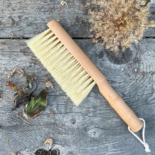 Seattle Seed Company multi-purpose gardener's brush with wooden handle and durable bristles for gardening and plant care.