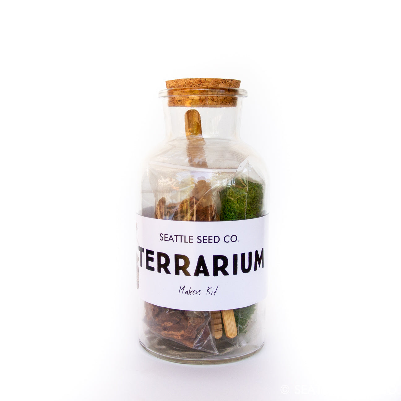 DIY terrarium kit from Seattle Seed Company with glass container, plants, soil, and decorative elements for creating a miniature indoor garden.