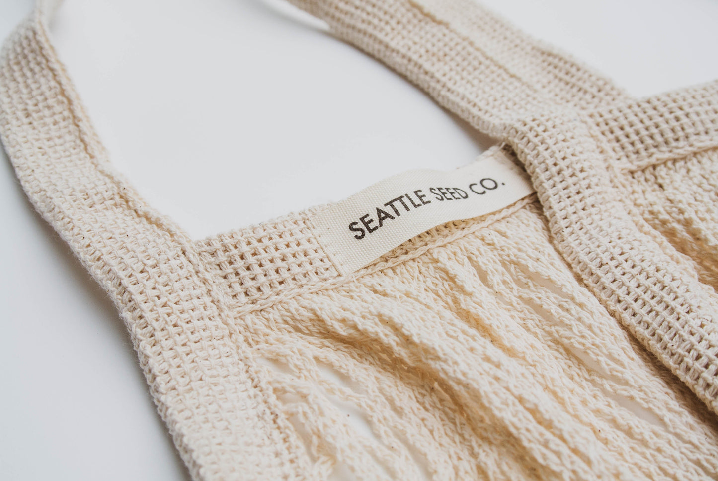 Cotton string French Market Tote bag by Seattle Seed Company with sturdy handles and spacious interior for shopping.