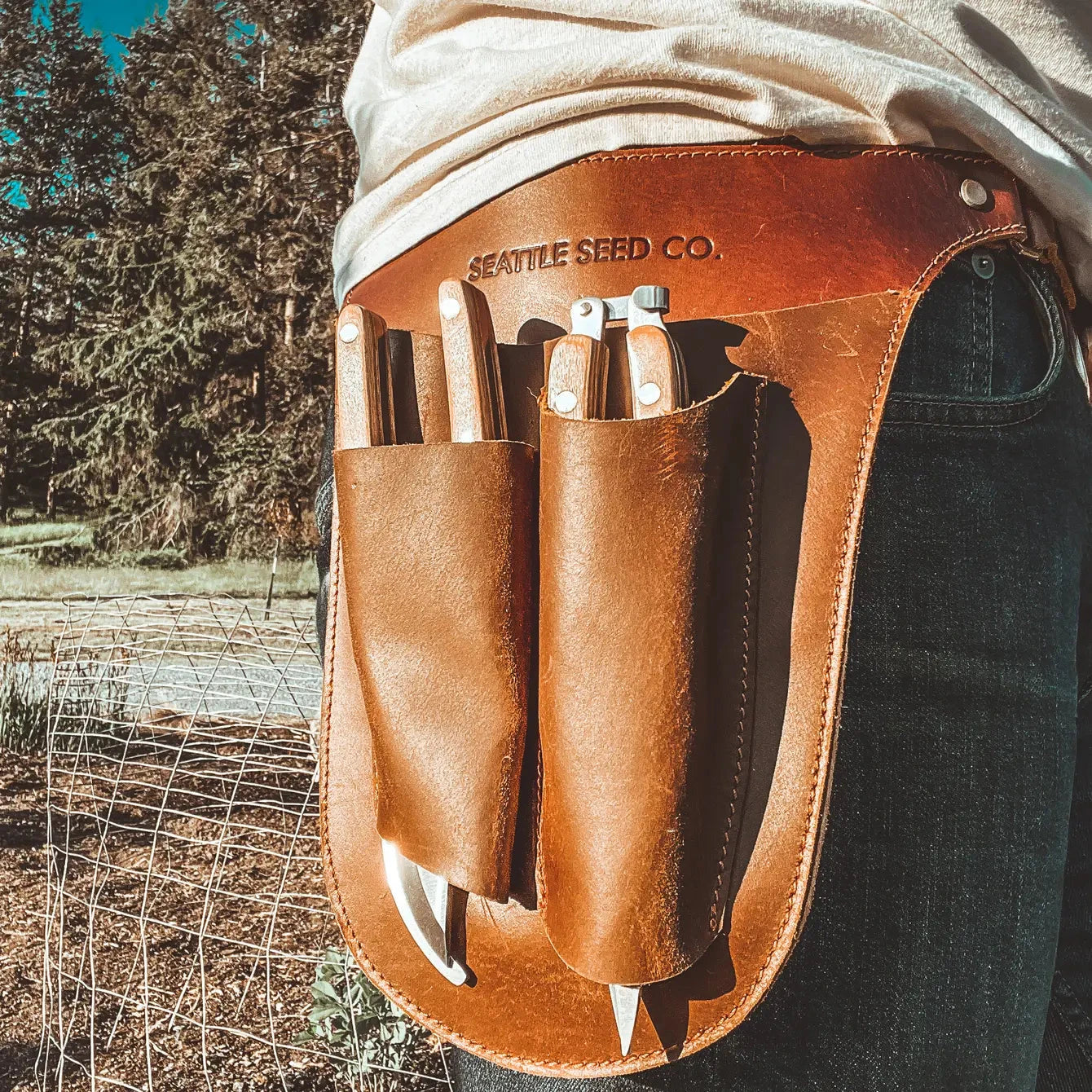 Harvest Essentials Gardener's Tool Belt by Seattle Seed Company in genuine leather, featuring multiple pouches and adjustable straps.
