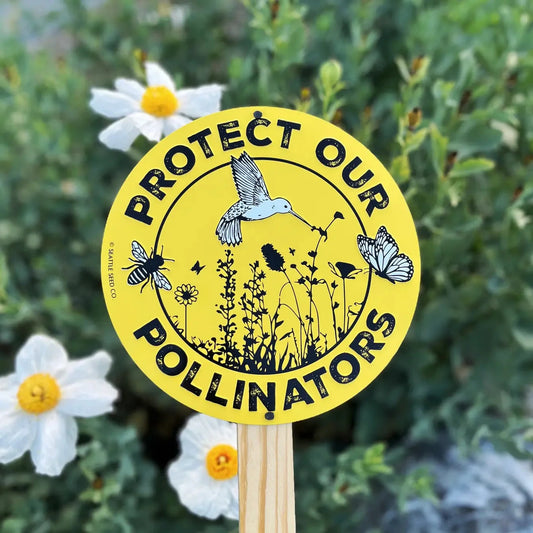 Metal garden sign by Seattle Seed Company with "Protect Our Pollinators" message, designed for outdoor garden decoration.