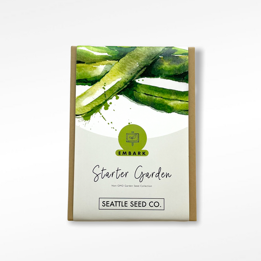 Seattle Seed Company starter garden seed collection with various vegetable and herb seeds in small packets for planting.