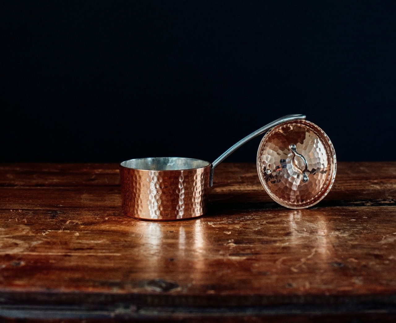 Side view of Sertodo petite French copper butter pot with lid and handle, showcasing its smooth, shiny surface and traditional design.