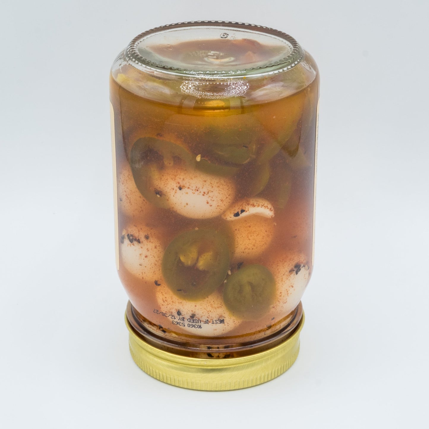 Canned spicy pickled quail eggs from Amish Country Store, showing a close-up of the jar with vibrant peppers and eggs inside.