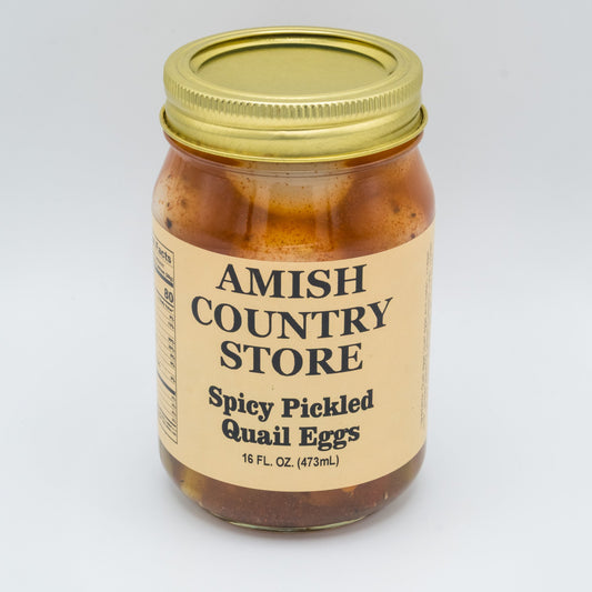Canned spicy pickled quail eggs from Amish Country Store in a jar with vibrant red chili spices and glossy eggs inside.