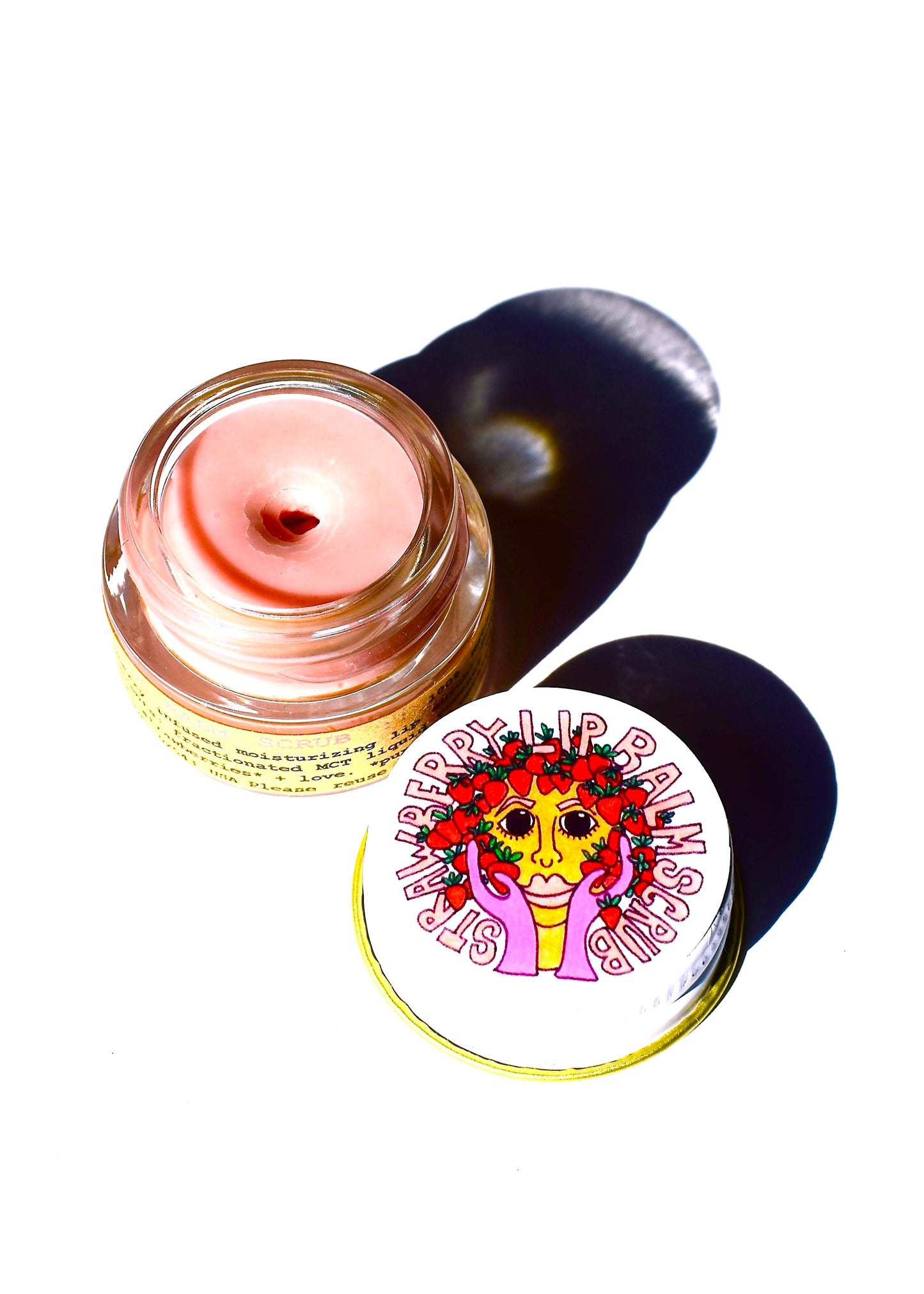 Plant Makeup Strawberry Dreamsicle Lip Balm Scrub featuring a jar with pink and white textured lip scrub with strawberry accents.