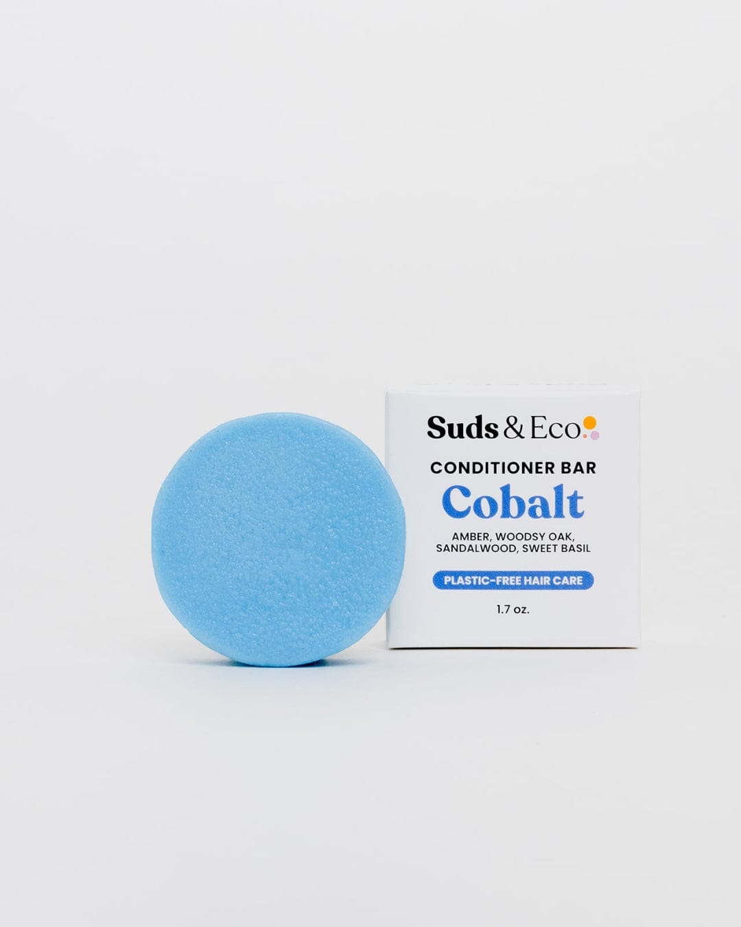 A round, light blue Conditioner Bar from ZeroWasteStore.com sits by its white box. Sulfate free and scented, this plastic-free bar delivers zero waste hair care for eco-conscious routines.
