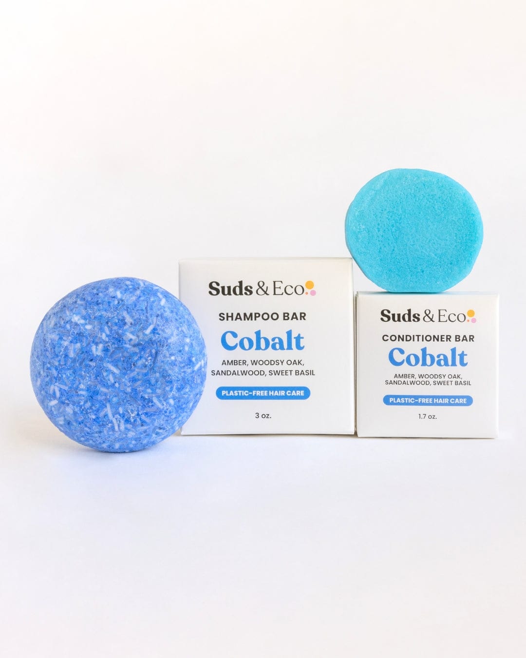 Two blue round bars, one large and one small, are shown with white boxes labeled ZeroWasteStore.com. The Shampoo & Conditioner Bar Duo sits against a plain white background. These zero waste bars offer an eco-friendly hair care solution.