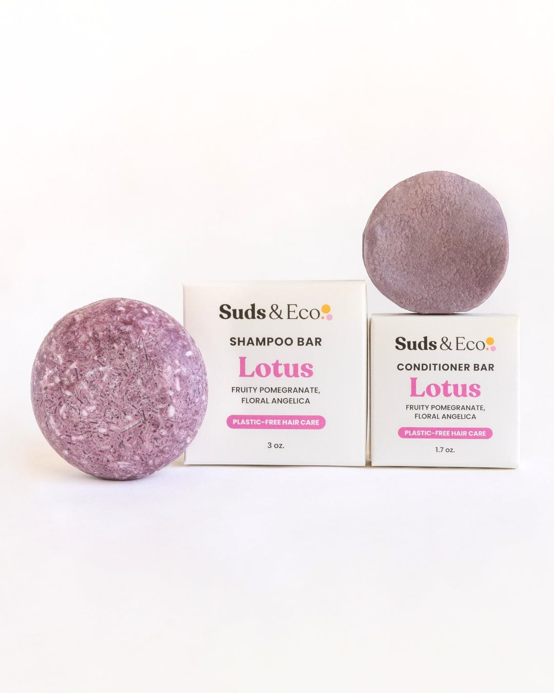 Two round Shampoo & Conditioner Bar Duos from ZeroWasteStore.com with Lotus scent featuring pomegranate and angelica notes are displayed by their labeled boxes—a clean, zero waste choice on a crisp white background.