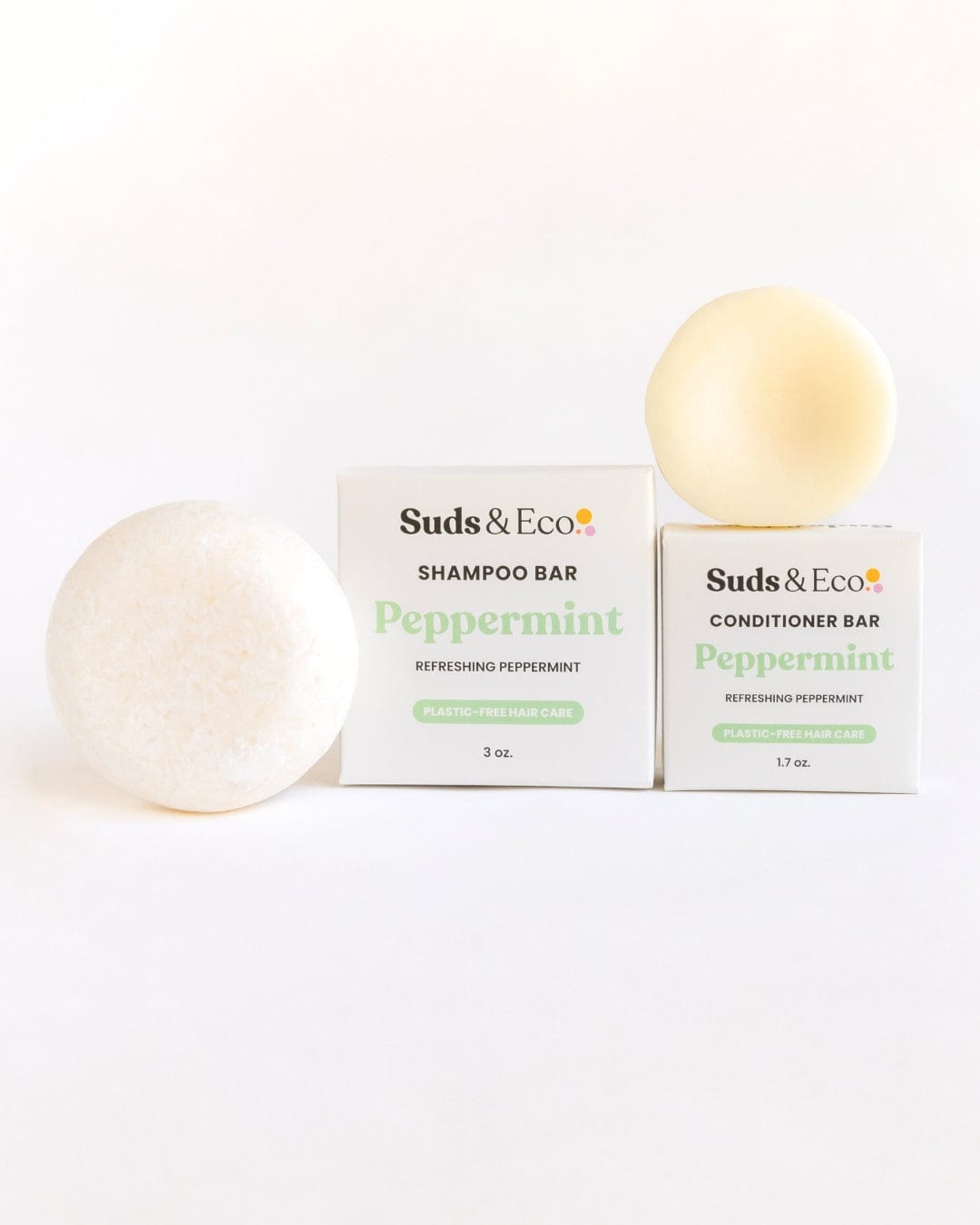 The Shampoo & Conditioner Bar Duo by ZeroWasteStore.com features two round bars beside branded boxes—perfect zero waste hair care for shampooing and conditioning, all on a clean white background.