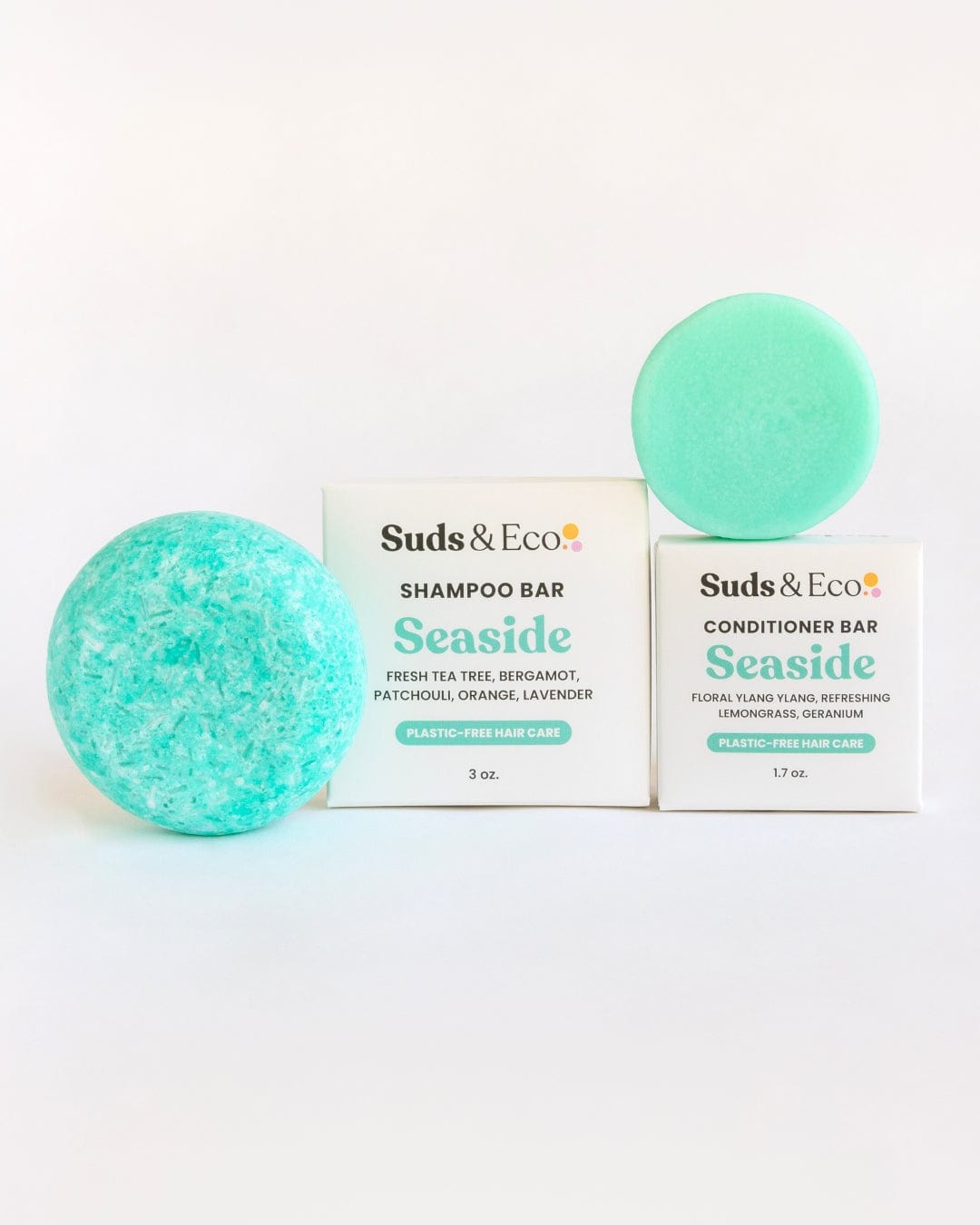 Two turquoise bars, one round and one disk-shaped, are shown with boxes labeled "ZeroWasteStore.com." The Shampoo & Conditioner Bar Duo provides a plastic-free hair care routine for eco-conscious users.