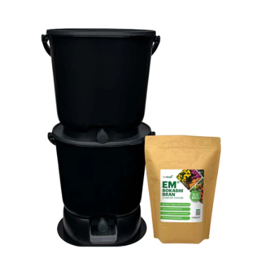 Two Teraganix Wholesale Essential Bokashi Compost Bin Starter Kits (4.4 gal) are stacked next to a brown EM® bokashi compost starter bag decorated with fruit and vegetable images—ideal for easy indoor composting.