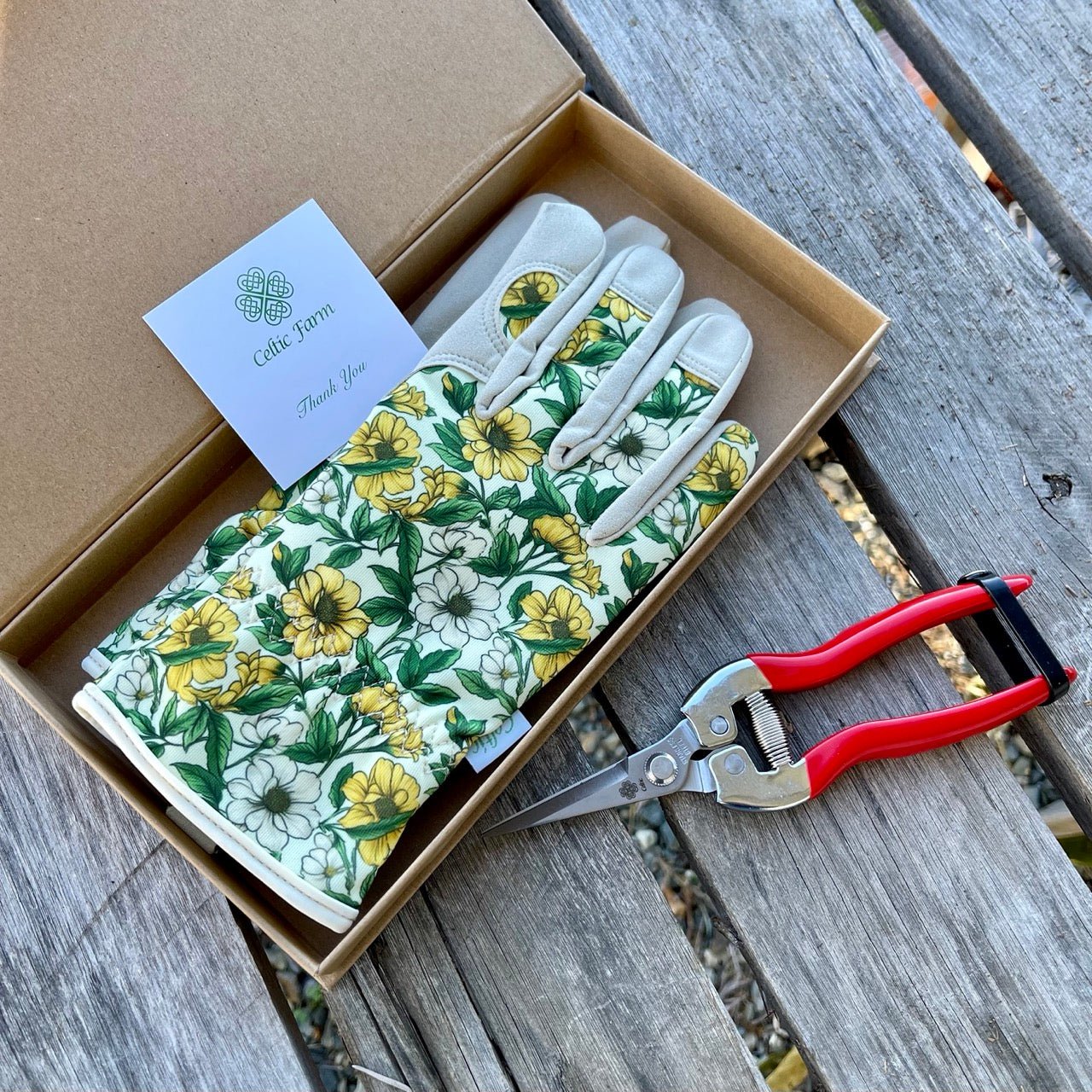 Garden Gift Box from The Celtic Farm with green and yellow gardening gloves and needle snips for plant care.