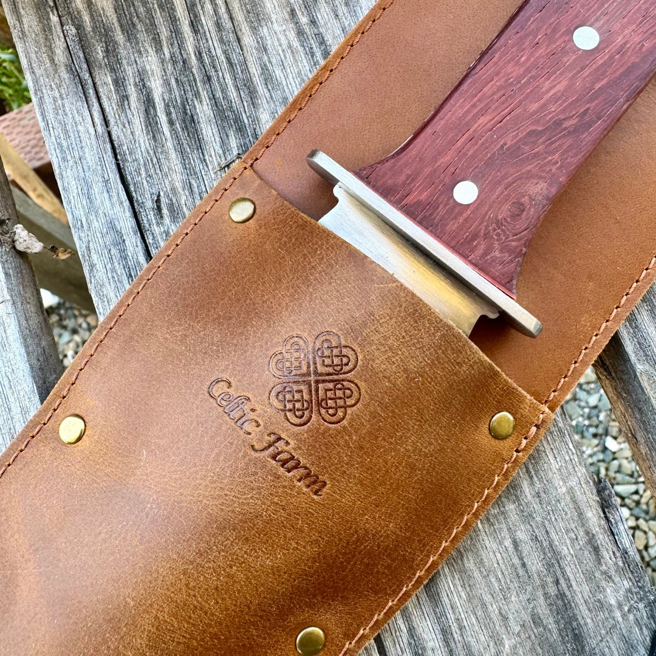 The Celtic Farm Hori Hori Garden Gift Box features a wooden-handled knife in a brown leather sheath embossed with a Celtic knot and Celtic Storm, offering a unique twist on the classic hori hori.