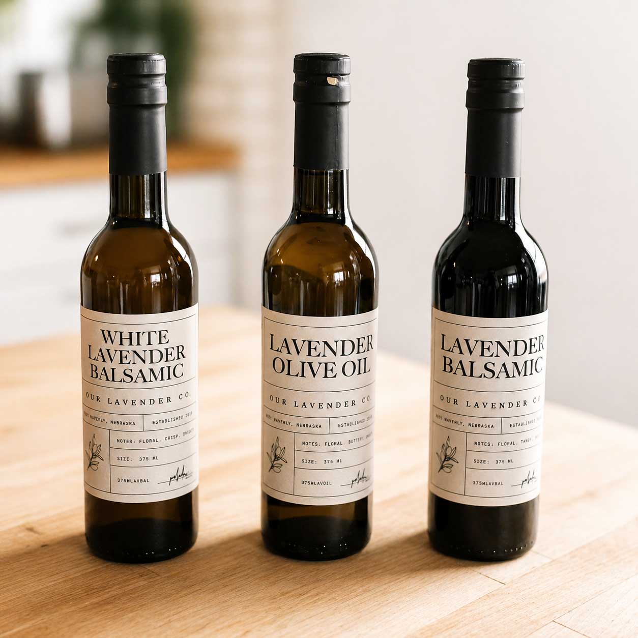 Three bottles of White Lavender Balsamic Vinegar from Our Lavender Co, showcasing clear bottles with white lavender-infused balsamic.