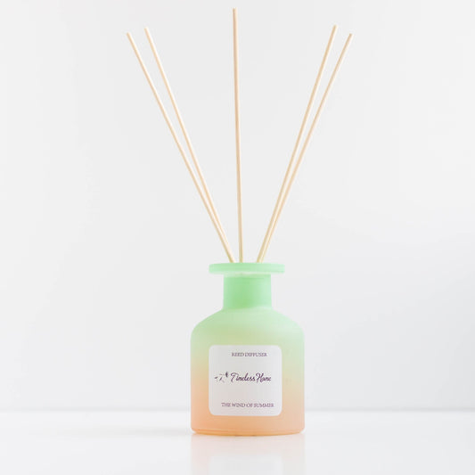 Reed diffuser labeled "The Wind of Summer" by Timeless Organics Skin Care with decorative reeds in a glass jar.