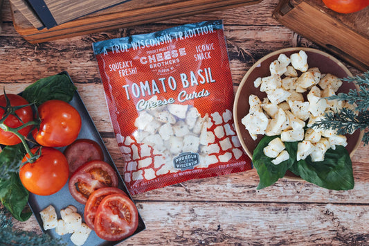 Fresh Tomato Basil Cheese Curds from Cheese Brothers, Inc. displayed in a bowl, showcasing vibrant tomatoes, basil, and creamy cheese curds.