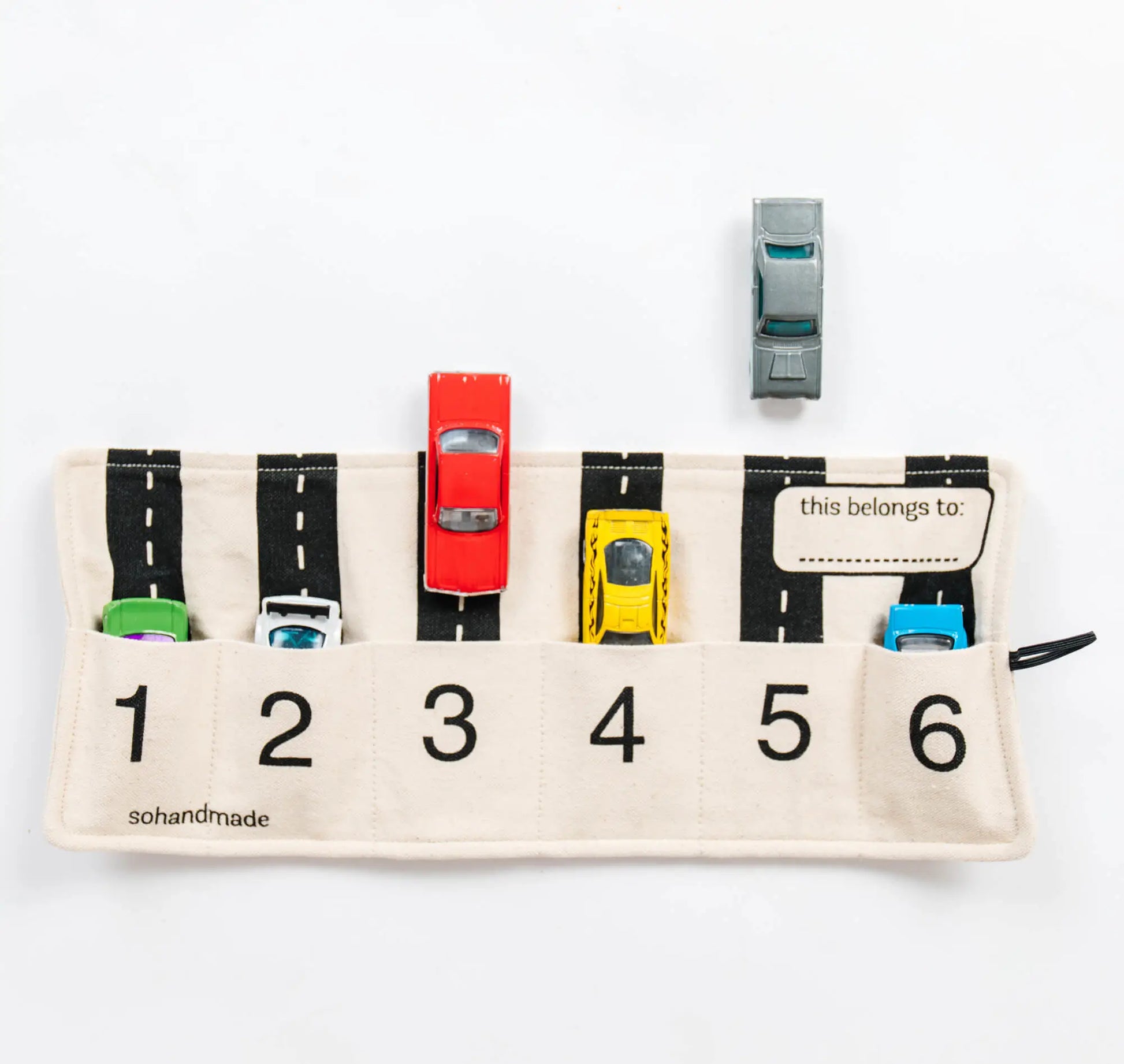 Toy car travel playmat by So Handmade Shop featuring colorful storage compartments for organizing small cars at home or on the go.