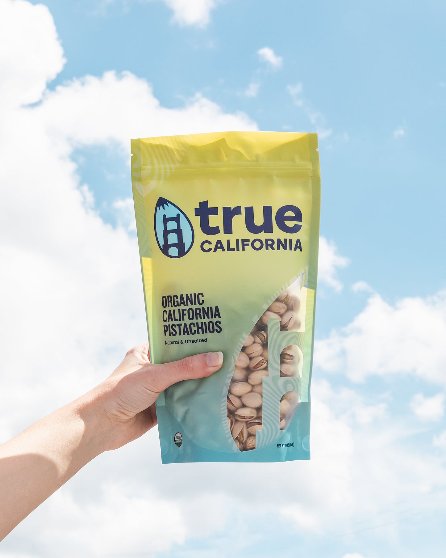 Organic True California pistachios in a 1lb bag, natural and unsalted, showing fresh green pistachios in their shells.