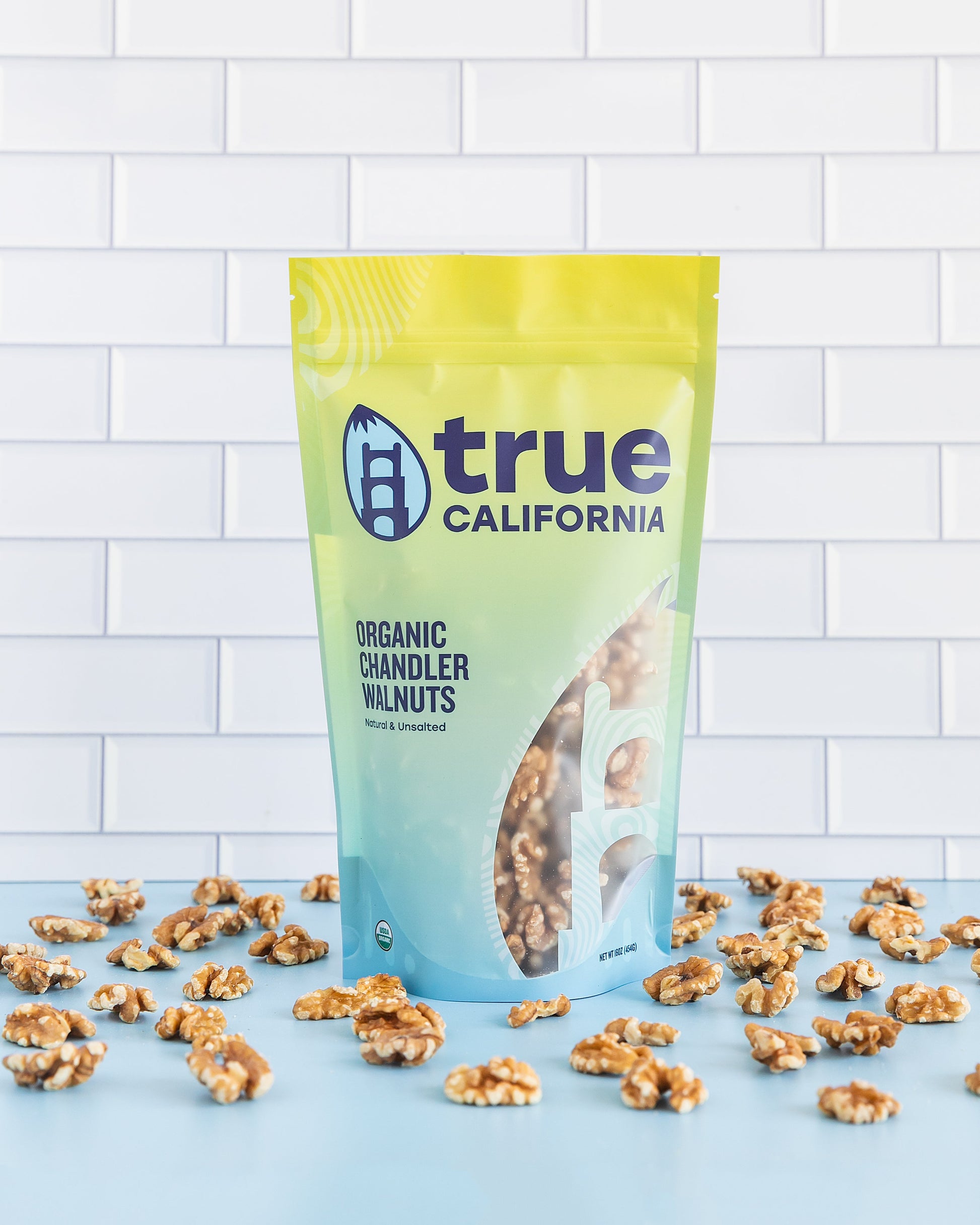 Organic Chandler walnuts from True California, showing a close-up of fresh, shelled walnuts in a clear container.