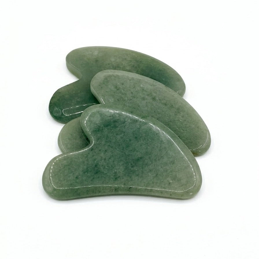 Green Jade Gua Sha facial massage stone by By Robin Creations, showing a smooth, curved jade tool on a neutral background.
